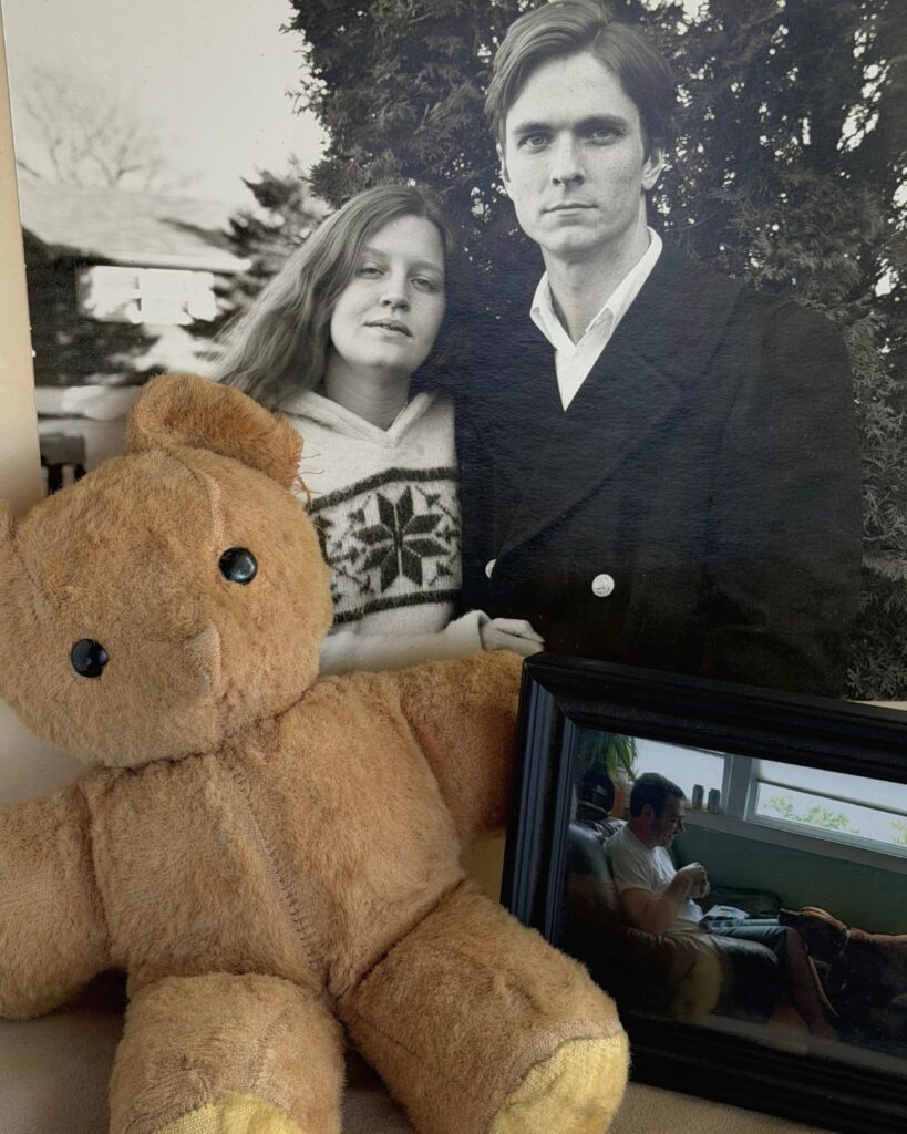 teddy bear leaning on old photo of couple, documenting memories